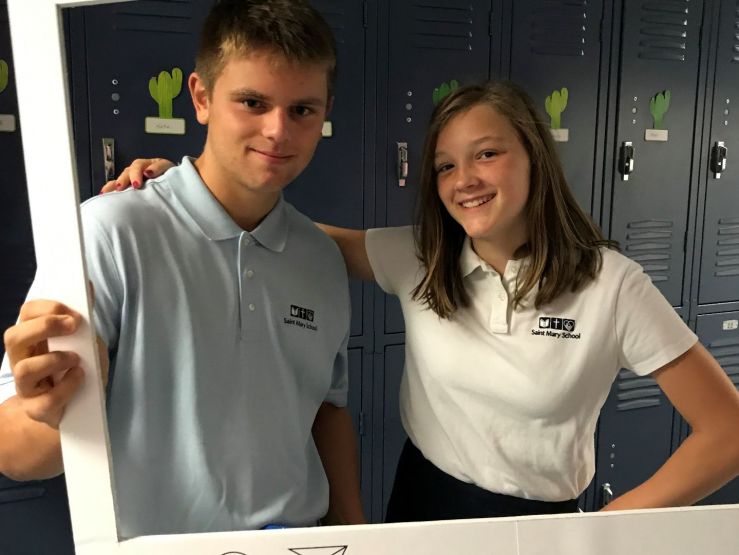 Boy and girl from Grade 8 standing in front of lockers