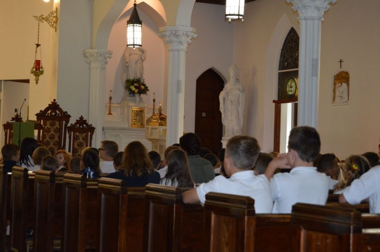 Students kneeling at Mass
